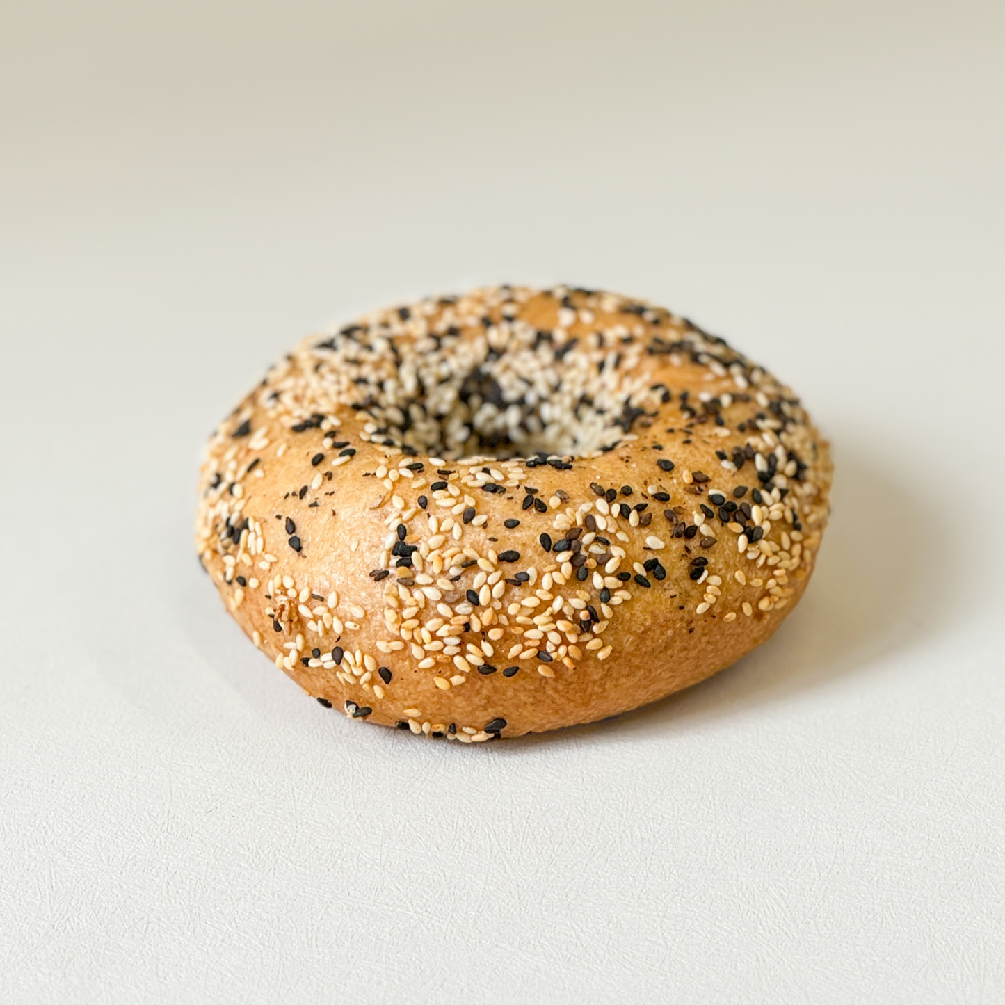 Gluten-free New York-style bagel with sesame from Happy Atelier Stockholm with a golden crust and soft center